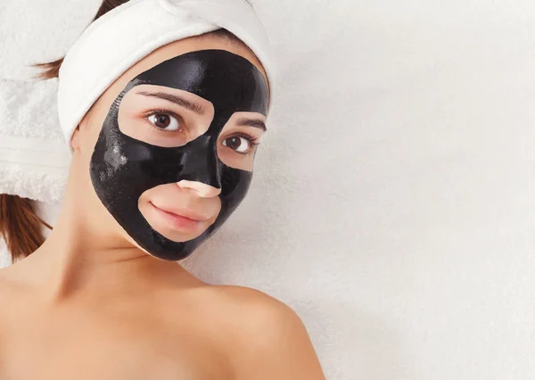 Chica joven con mascarilla negra purificante —  Fotos de Stock