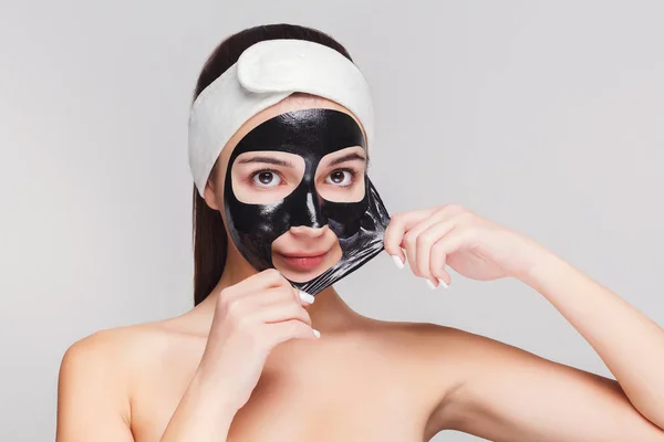 Jovem com purificação máscara facial preta — Fotografia de Stock