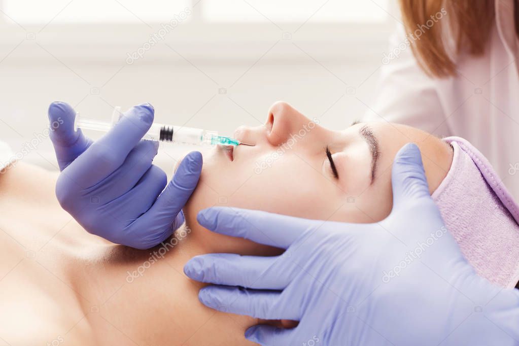 Woman getting beauty injection at salon