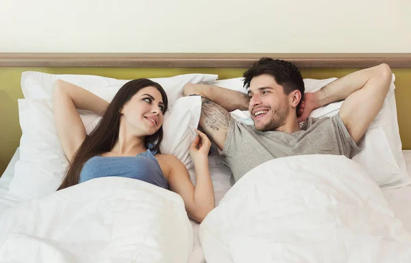 Feliz jovem casal acordar de manhã na cama — Fotografia de Stock