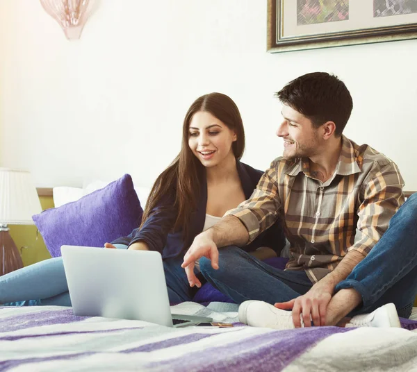 Casal amoroso usando laptop no quarto de hotel — Fotografia de Stock