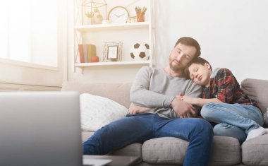 Yorgun baba ve oğul evde kanepede uyuyor