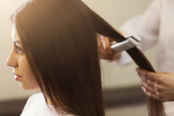 Fryzjer prostowania długich brązowych włosów — Zdjęcie stockowe