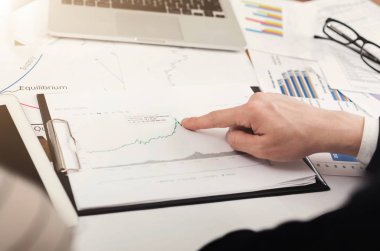 Grafikte sunulan verilere işaret eden işadamı