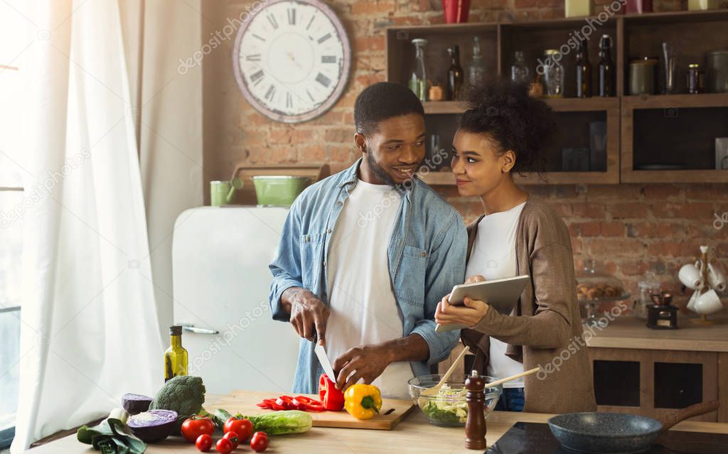 African-american couple searching for recipe using digital tablet