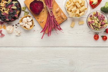 Beyaz tahtaya üstten görünüm çeşitli renkli makarna kase