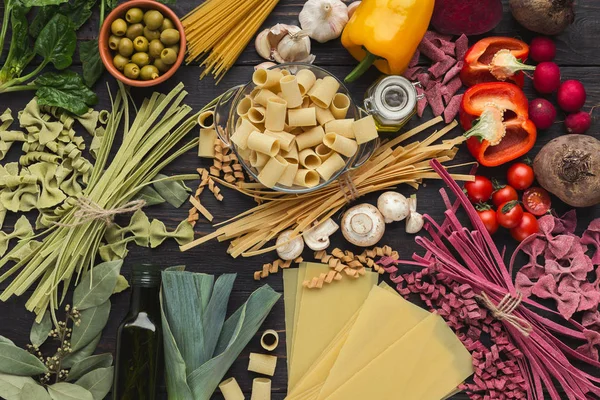 Mixed italian pasta and vegetables on brown wood, top view — Stock Photo, Image
