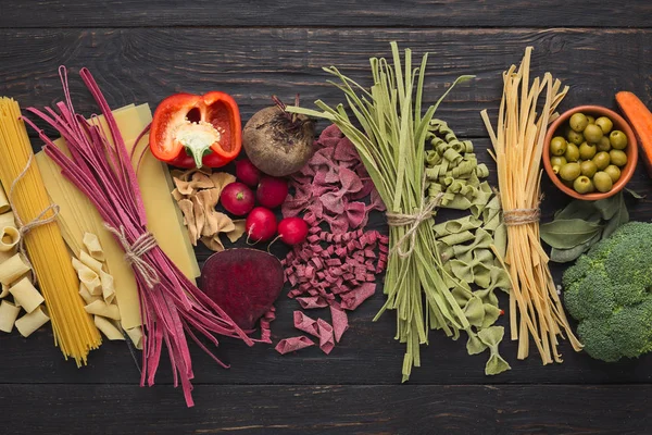 Assorted colorful pasta bowls on rustic wood, top view — Stock Photo, Image