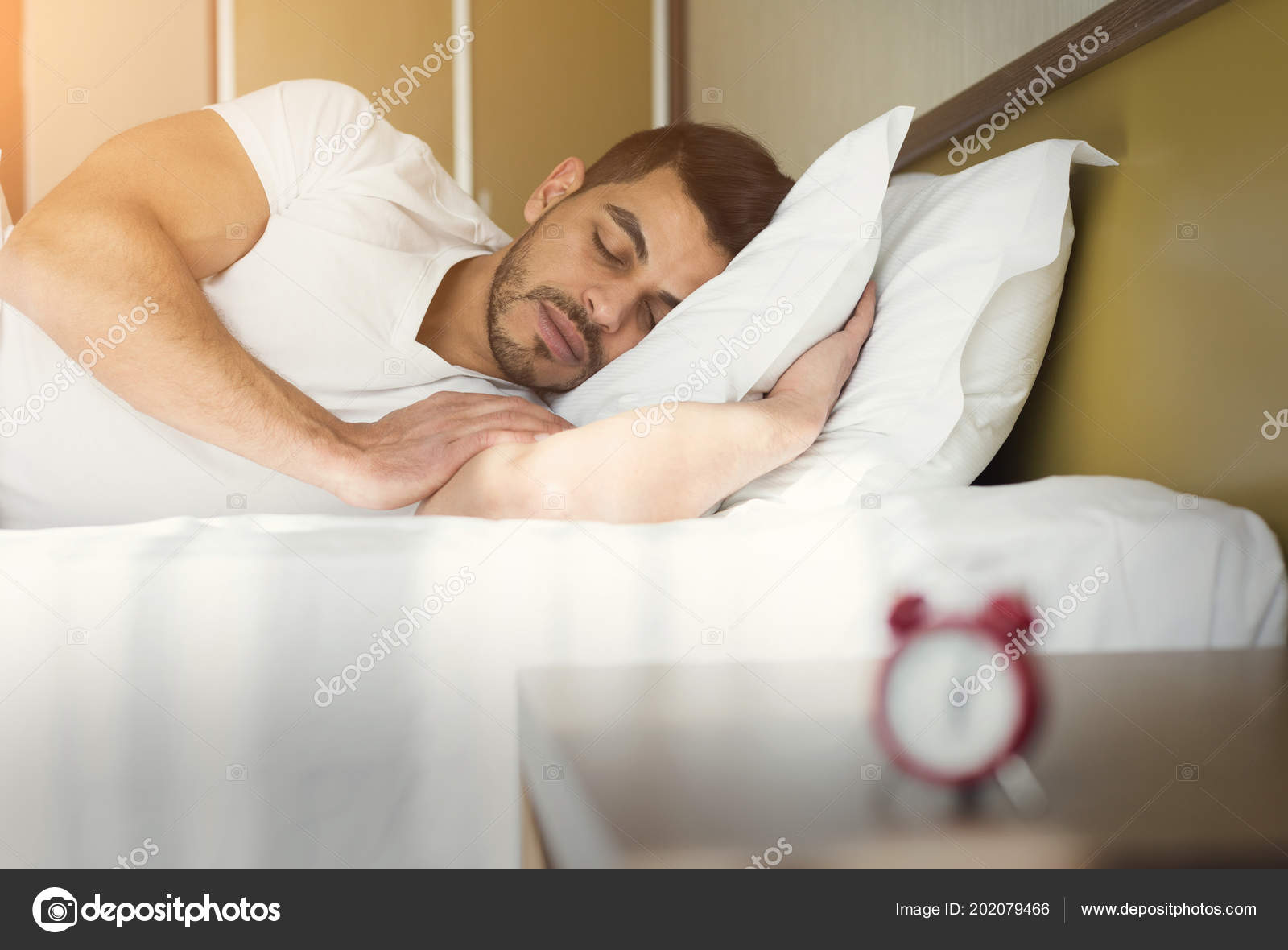 Side view of handsome man sleeping in bed Stock Photo by ©Milkos 202079466