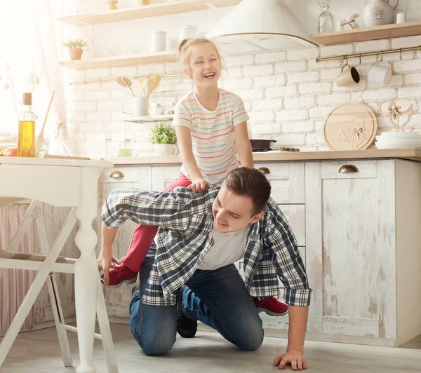 Father and little daughter play horse-ride