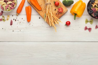 Beyaz tahtaya üstten görünüm çeşitli renkli makarna kase