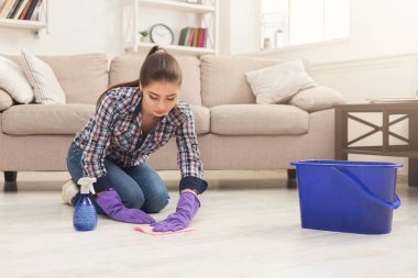 Concentrated woman polishing wooden floor clipart