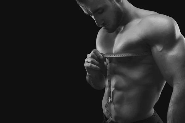 Hombre musculoso fuerte que mide el pecho — Foto de Stock