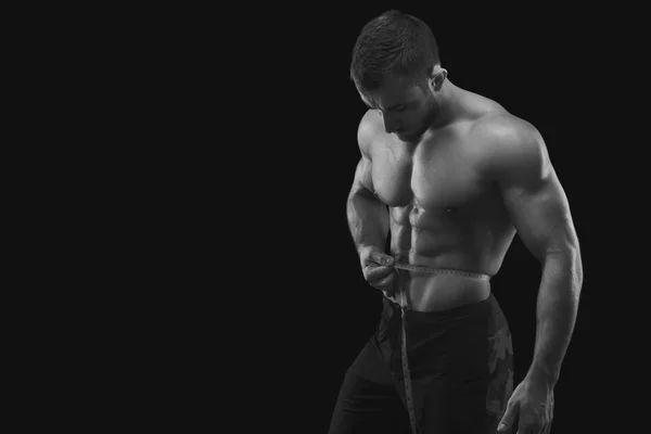 Forte uomo muscolare che misura la vita — Foto Stock