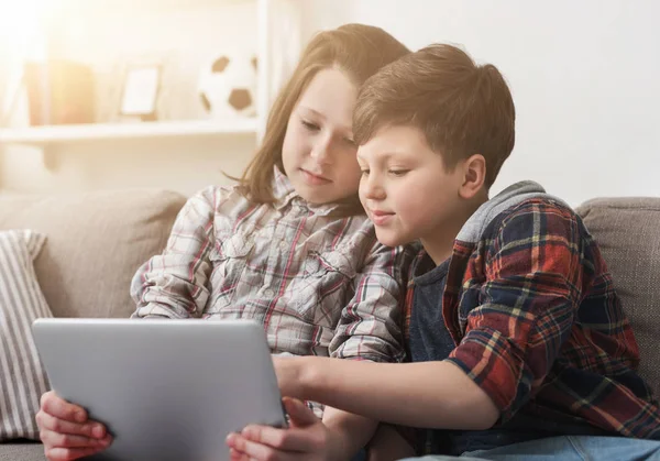 Två barn titta på film på digitala tablett hemma — Stockfoto