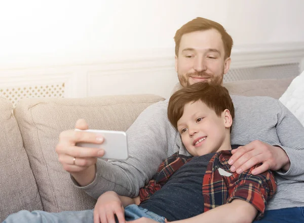 Ojca i syna biorąc selfie w domu — Zdjęcie stockowe