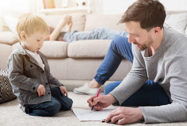 Father drawing with his little cute son