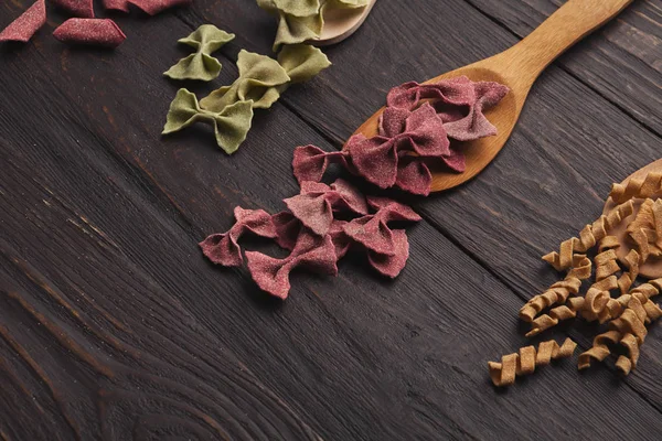 Surtido de pasta colorida en la mesa de madera, espacio para copiar — Foto de Stock