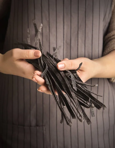 Mulher segurando fettuccine com tinta de choco — Fotografia de Stock