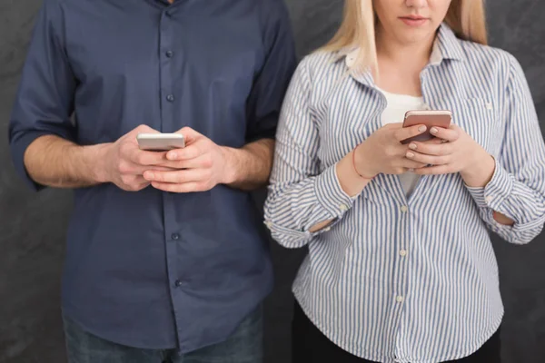 Молодая неузнаваемая пара игнорирует друг друга с помощью телефонов — стоковое фото