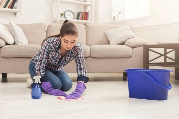 Концентрована жінка полірує дерев'яну підлогу — стокове фото