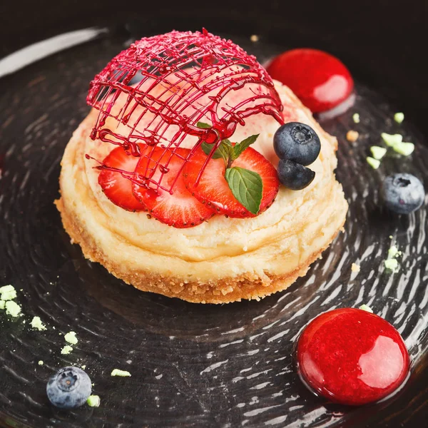 Lemon cheesecake with berry spheres served at modern restaurant — Stock Photo, Image