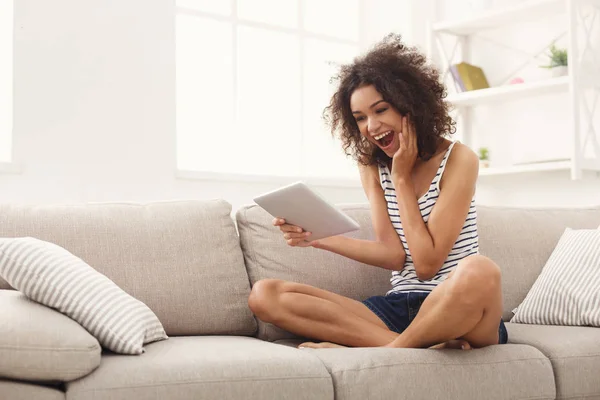 Joven chica emocionada con tableta digital en casa — Foto de Stock