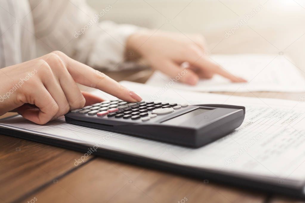 Woman hands with calculator and papers