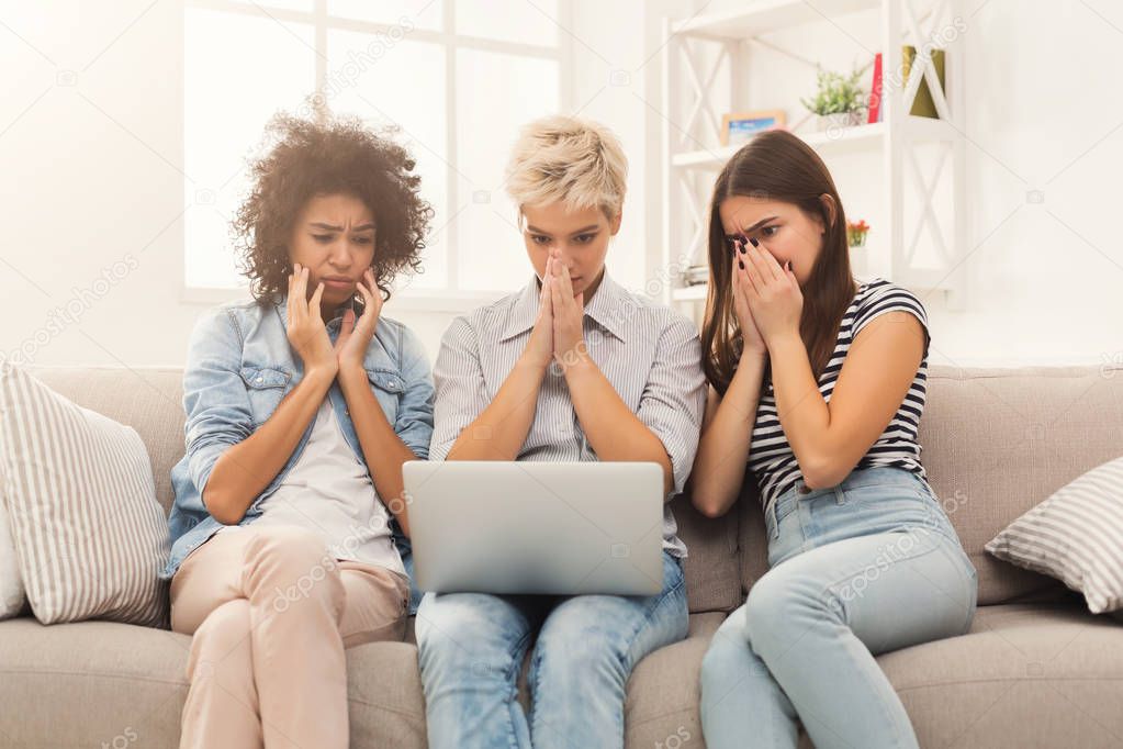 Three sad women using laptop at home