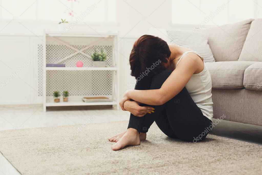 Upset girl sitting on the floor