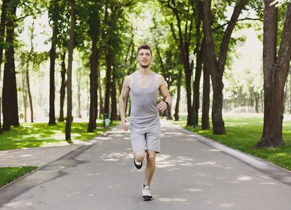 Joven corriendo en el parque verde, espacio para copiar —  Fotos de Stock