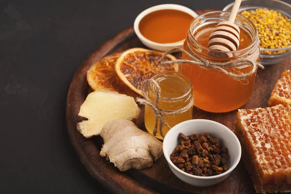 Various types of honey on wooden platter, closeup — Stock Photo, Image