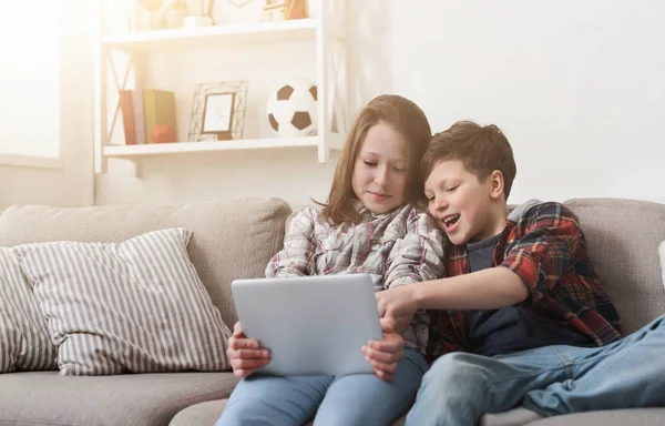 Syster och bror titta på film på digitala tablett hemma — Stockfoto