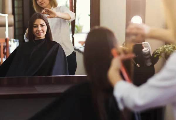 Spegelbild av ung kvinna i salong — Stockfoto