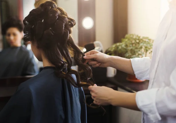 Parrucchiere rendendo i capelli ondulati al cliente — Foto Stock