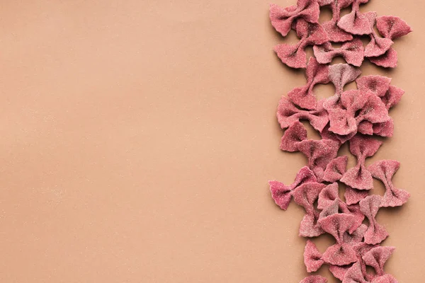 Gränsen av röd rosett pasta på rosa bakgrund — Stockfoto