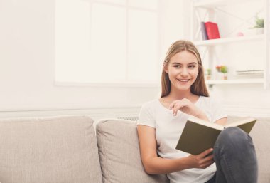 Rahat ev. Kitap ile genç gülümseyen kadın