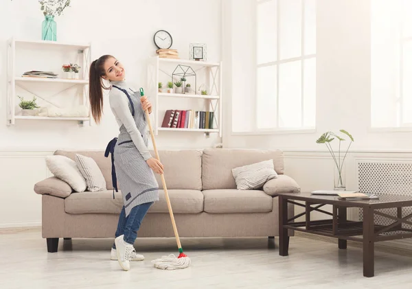 Szczęśliwa kobieta sprzątanie domu z mopem i zabawy — Zdjęcie stockowe