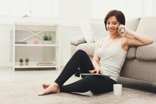 Mädchen nutzt Tablet und spricht auf Smartphone — Stockfoto