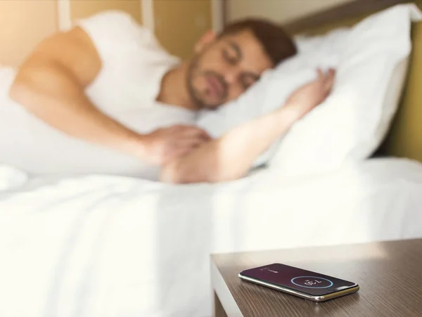 Hombre durmiendo en la cama mientras escucha el despertador —  Fotos de Stock