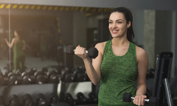 Donna fitness con manubri in palestra — Foto Stock