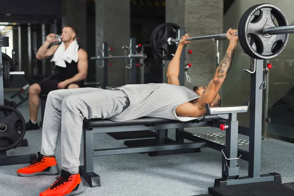 Dos hombres haciendo ejercicio con mancuerna en el gimnasio —  Fotos de Stock