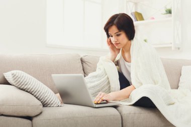 Bir battaniye ile bir dizüstü bilgisayar çalışma kız