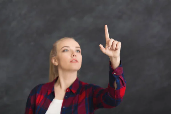 Junge Frau zeigt auf virtuelles Objekt — Stockfoto