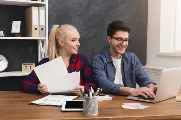 Couple of young colleagues work at modern office