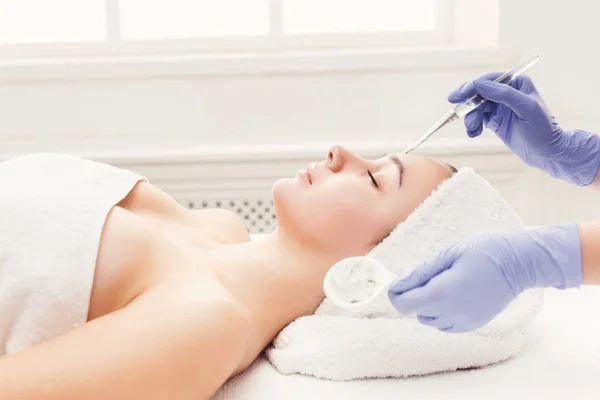 Kvinna får ansiktsmask av kosmetolog på spa — Stockfoto