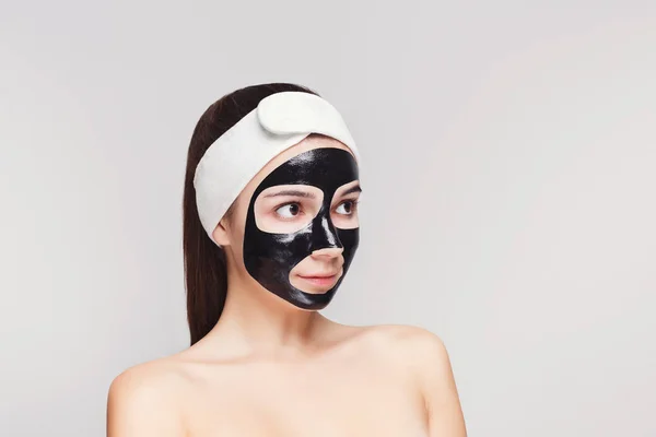 Jovem com purificação máscara facial preta — Fotografia de Stock