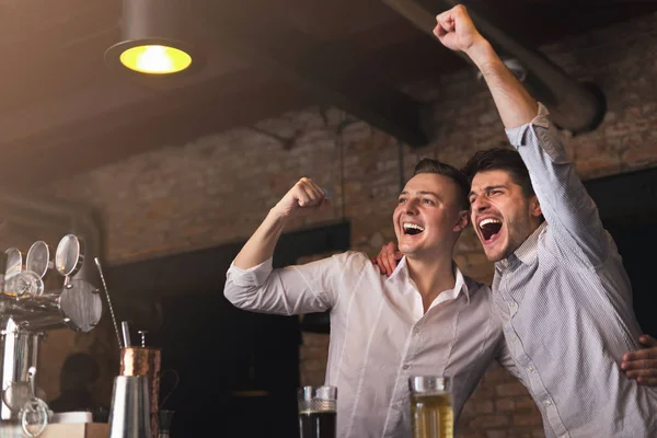 Amigos felices animando a su equipo favorito en el pub —  Fotos de Stock