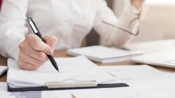 Young successful woman writing notes while sitting in office — Stock Photo, Image