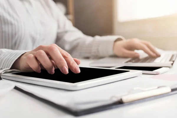 Kvinna som arbetar på laptop och digitala tablett på kontor — Stockfoto